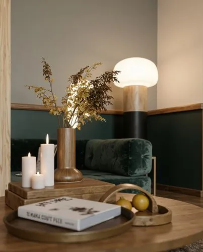 A close-up of a stylish coffee table adorned with dried flowers, candles, and minimalistic decor. A dark green velvet sofa and a glowing floor lamp create a warm and sophisticated background.,a small 