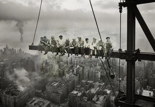 construction workers on surrounding steel beams working diligently, welding, hammering, and securing rivets. Nearby, a large pulley system hoists heavy steel beams into position, with ropes and cables