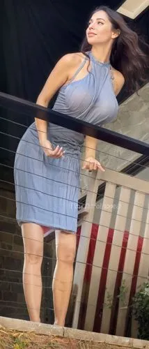 a woman in a gray top and blue skirt stands on a porch,girl on the stairs,run,poise,distort,trampoline,jiggle