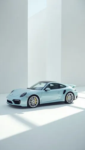 Pale baby blue Porsche 992 Turbo S with white wheels, parked in the middle of an empty white photography studio. The car is centered and illuminated by bright overhead lighting, casting soft shadows o