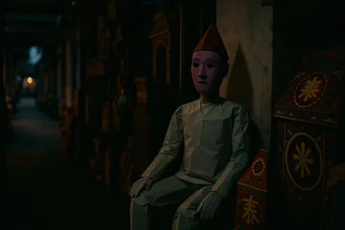 a toy sits in the corner of a room,doorkeeper,shopkeeper,wooden doll,narrow street,corridors,day of the dead frame,depth of field,miniaturist,corridor,in the shadows,alleyway,souks,clay doll,shopkeepe