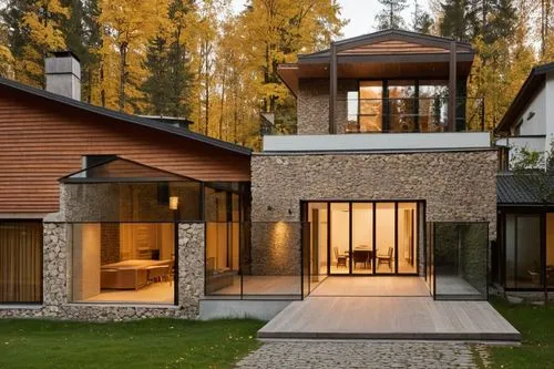 the entry to a building that has large glass doors,forest house,modern house,cubic house,timber house,private house,summer house,chalet,modern architecture,luxury property,wooden house,beautiful home,