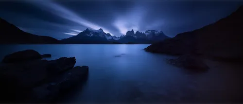 a lake filled with mountains at night with clouds,blue caves,enchantments,blue cave,blue light,light of night,virtual landscape,fantasy landscape,the blue caves,nightlight,volumetric,fractal environme