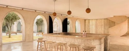 Interior de estilo mediterráneo moderno con un diseño minimalista y materiales cálidos. Espacio abierto con paredes de estuco beige claro y múltiples ventanales en forma de arco con marcos de madera n