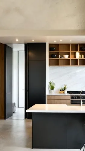 An indoor frontal view of a light colored kitchen, with a light colored wooden cabinetry and stainless steel stove on the right. The cabinets are white, with gray grout on the shelves. Below the cabin
