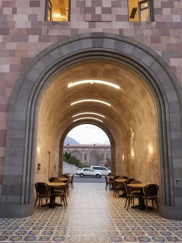 Replace the sidewalk in front of the building with ornamental tile flooring as in Italy. Add arched cafe tables beneath the arch. Maintain the wall configuration and stone coating from tufted stone. E