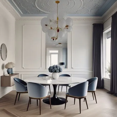 a white round table surrounded by blue chairs in a room,dining room table,dining table,danish room,dining room,danish furniture,breakfast room