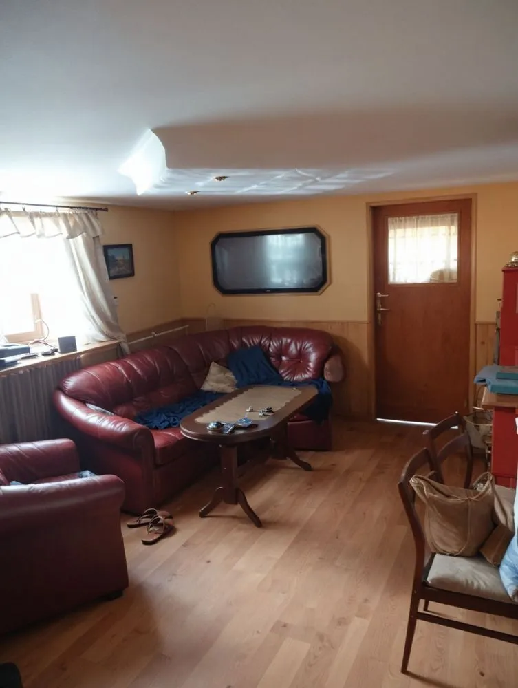a living room with red leather couches and two chairs