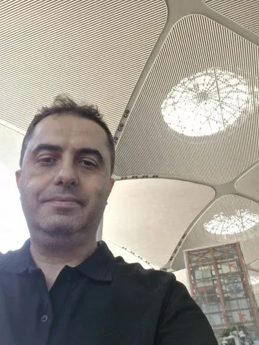 The curved roof opens and black-clad commandos enter the building with ropes. The skylight opens and the commandos descend.,a man in blue shirt standing under a white ceiling,bursa,the airport termina