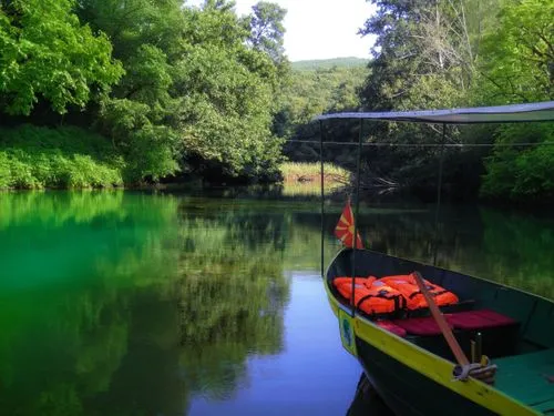 a boat in a green lake,a boat docked at the edge of a river,the danube delta,danube delta,king decebalus,cenote,green water,giverny,decebalus,jezero,warrandyte,neretva,evros,wekiva,telaga,huka river,t