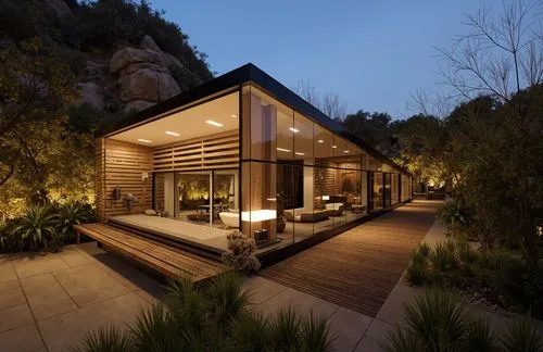 A tropical-modern house with stone and wood cladding. The exterior features desert landscaping with tall cacti and boulders. Warm lighting accentuates the facade's textures,a modern house in the woods