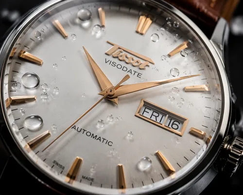 a macro shot of a Tissot Heritage Visodate Automatic T118.430.16.051.00
 watch, with droplets on its face
,a watch with two dials that are white with gold hands,chronographs,chronometer,horological,me