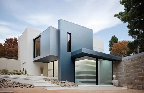 DISEÑO DE UNA CASA RESIDENCIAL EN ESQUINA CON UN VENTANAL EN ESQUINA , CON CANCELES DE ALUMINIO Y CRISTAL, EXCELENTE REPRESENTACIÓN, PROPORCION, VEGETACION EXUBERANTE,the front of this modern home fea