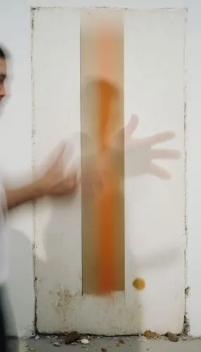 A blurry, surreal scene: a man's left side is shrouded in mist. His right hand is pushed forward, while his left hand is straight across. His face is not fully visible due to being displaced and the m