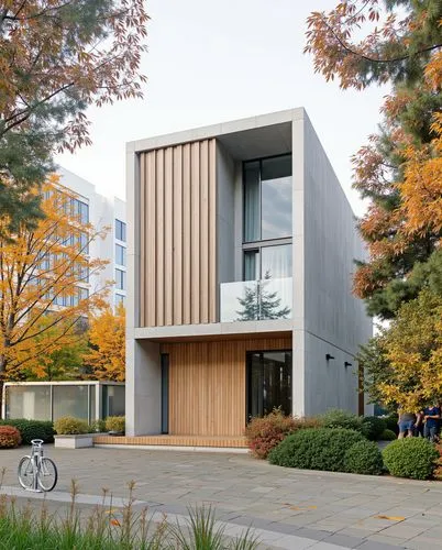 Modern, Rectangular concrete structure, vertical wooden slats on the facade, large glass panels reflecting surrounding trees, Balanced geometry, Autumn foliage with golden and amber leaves, Paved ston
