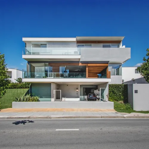 Vivienda unifamiliar en dos niveles a media altura , arquitectura minimalista en colores claros,a large white home with glass windows overlooking a street,modern house,modern architecture,weatherboard