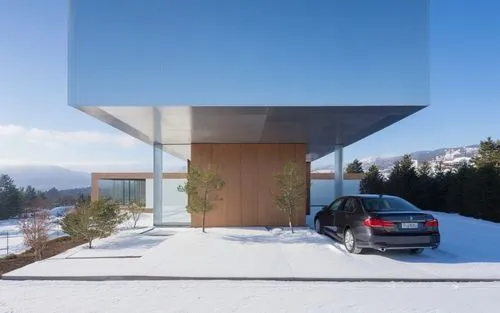 a car parked under an enclosure with a snow covered hillside in the background,cubic house,cube house,house in mountains,house in the mountains,snohetta,snow roof