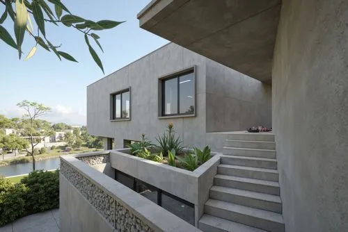 A photo-realistic shoot from a bird's eye view about a modern, minimalist house with a concrete exterior and a green roof, situated on a hillside overlooking a lake. the image also shows a serene land