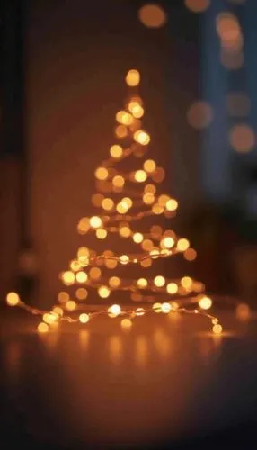 A minimalist Christmas wallpaper featuring fairy lights, styled with warm hues tones, evoking a festive and cheerful atmosphere.,there is a lit christmas tree on the table,christmas tree with lights,t