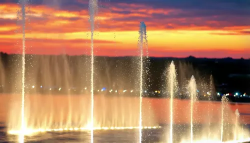 Create a breathtaking, ultra-cinematic slow-motion video of a majestic dancing fountain performance at golden hour. The fountains gracefully choreograph intricate patterns and dynamic water jets illum