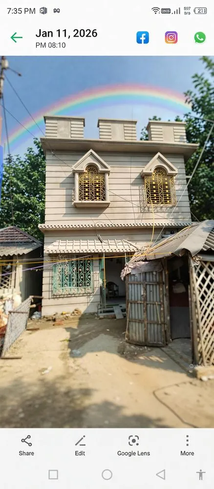an old white building with four windows and white porching