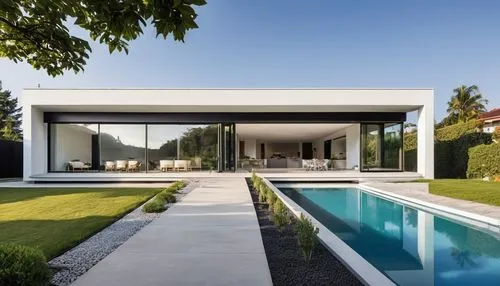 "Un modelo arquitectónico minimalista de una casa elevada sobre pilares, con un diseño moderno y limpio. La vivienda tiene un techo plano de concreto, ventanas rectangulares con marcos de aluminio neg