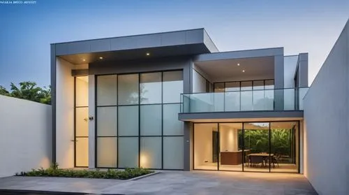 the entrance of a home with glass doors at night,modern house,modern architecture,cubic house,glass facade,cube house,glass wall,luxury home,modern style,contemporary,luxury property,beautiful home,st