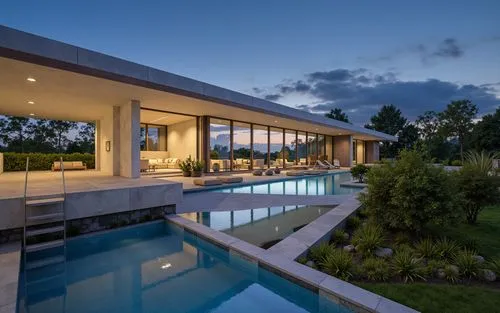 A photo-realistic shoot from a bird's eye view about a modern, minimalist house with a concrete exterior and glass walls, situated on a hillside at dusk. the house is situated on the left side of the