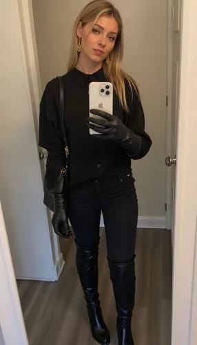 Quick, spontaneous mirror selfie video: The blonde girl, 18, records a fast mirror selfie video before heading out. She’s wearing black leather thigh-high boots with chunky platform heels and square t