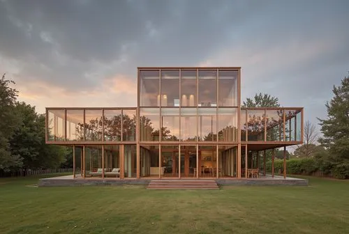 a house sitting in the middle of a green field,cubic house,glass facade,cube house,structural glass,mirror house,glass building,glasshouse,modern house,modern architecture,timber house,frame house,bun