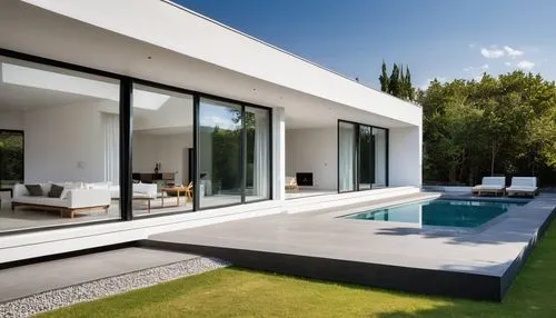 "Un modelo arquitectónico minimalista de una casa elevada sobre pilares, con un diseño moderno y limpio. La vivienda tiene un techo plano de concreto, ventanas rectangulares con marcos de aluminio neg