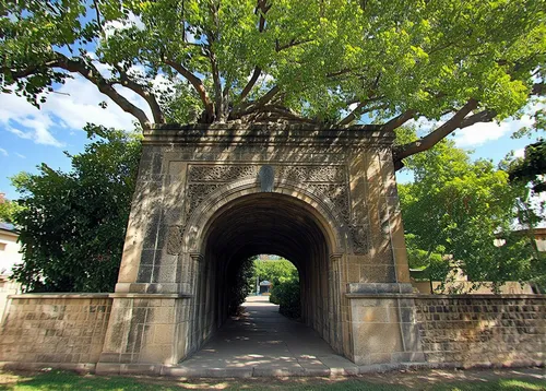 A majestic stone archway adorned with intricate carvings, nestled within the branches of a towering tree. The archway appears to be a gateway to another world, with its dark and mysterious interior. T