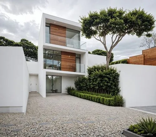 A photo-realistic rendering of a modern, minimalist two-story house with a contemporary design. the house is located in the middle of the image, with a large tree on the right side and a gravel drivew