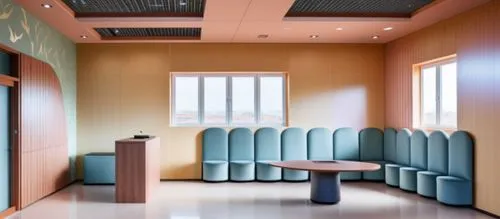 international kids school reception area n waitng area ,a table sits in the middle of a room filled with blue chairs,examination room,treatment room,doctor's room,therapy room,hospitalier,consulting r