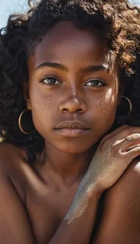 A close-up shot of a round topographic piece of land that is a portrait of an ebony girl with beautiful hair and freckles. Her eyes are fixed to the sky, and they are completely closed showing only he