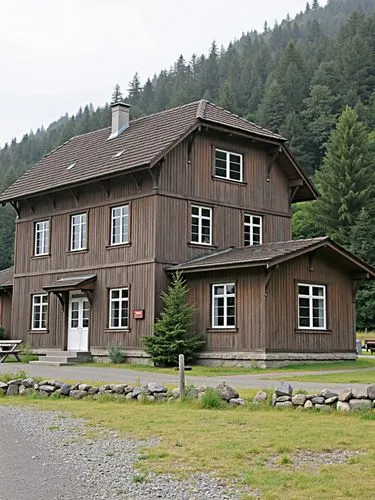 A typical country station of the former Württemberg State Railways.,an old style brown wooden building next to a forest,gasthof,landhaus,glickenhaus,stutthof,osterhaus,staatseisenbahnen,lockenhaus,cha
