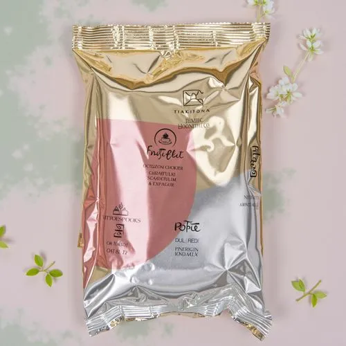 Three sleek foil sachets displayed on a modern, glossy surface, each slightly different in color and design to represent various product types. The sachets are made of smooth metallic material, reflec