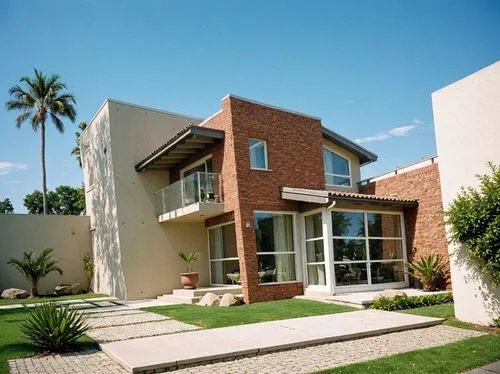 PHOTOGRAPH TAKEN WITH A KODAK CAMERA, WITH A 35MM LENS of a modern two-story house with a contemporary design, featuring a combination of brick and concrete. the house has large windows, sliding glass