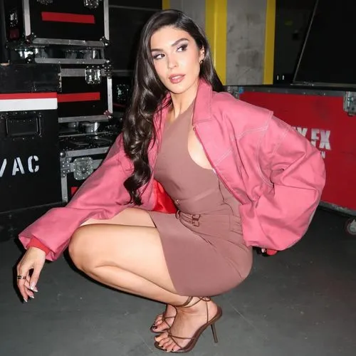 a very  lady sitting on the floor with her foot on a piano,backstage,thighs,squatting,arias,thigh,leggy,crossed legs,pink shoes,legs,jumpsuit,romper,beautiful legs,diva,legs crossed,looking through le
