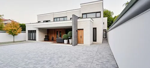 Render hiperrealista de una casa moderna con fachada minimalista en tonos blancos y grises. La estructura presenta líneas limpias, grandes ventanales con marcos oscuros y detalles en piedra. El jardín