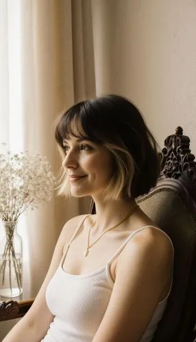 A realistic photograph presents a medium close-up portrait of a woman with a tousled chin-length dark brunette bob accented by bold blonde money-piece highlights framing her face, seated slightly righ