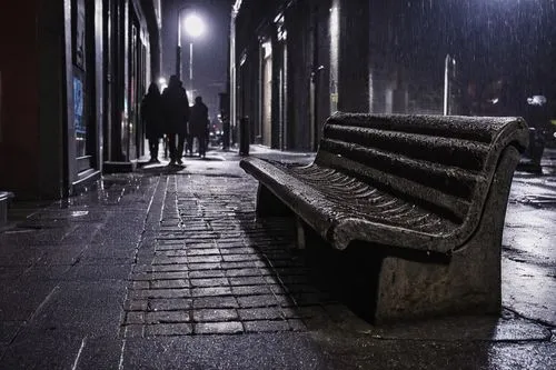 Hostile architecture, urban cityscape, concrete benches with armrests, metal spikes on ledges, curved or pointed edges, cold tone lighting, rainy night, dark alleys, trash cans, broken bottles, lonely