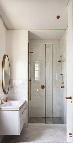 The shower enclosure features (((white marble walls with subtle grey veining))), The glass doors, adorned with gold handles and fixtures, provide a seamless entry. A minimalist light rose vanity cabin