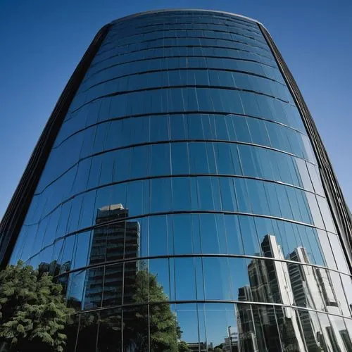 Streamlined architecture, modern skyscraper, sleek glass façade, silver metallic accents, curved lines, minimalist design, urban cityscape, daytime, clear blue sky, few white clouds, dramatic shadows,