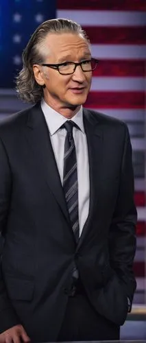 Bill Maher, middle-aged man, comedian, talk show host, sharp facial features, glasses, gray hair, suit, white shirt, black tie, microphone in hand, standing, confident pose, American flag in backgroun