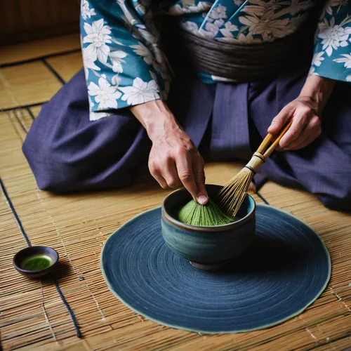 High angle close up of Japanese man wearing traditional kimono kneeling on floor using bamboo whisk to prepare Matcha tea in a blue bowl during tea ceremony, Kyushu, Japan,tea ceremony,gyokuro,tatami,