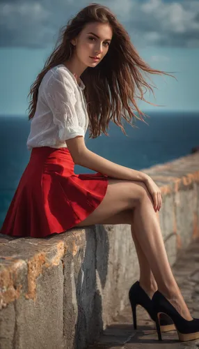 Girl with long legs and a red micro skirt sitting on the wall looking at the sea,red skirt,girl in red dress,red shoes,man in red dress,female model,portrait photography,girl on the dune,a girl in a d