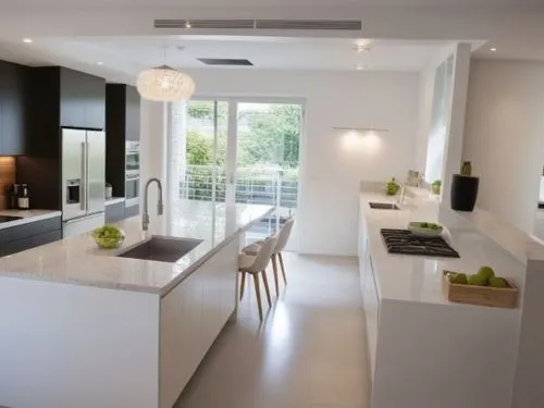 A modern kitchen design where all the cabinets are in a clean white color, and the countertop is also white. The kitchen features sleek, minimalist lines with smooth, handleless cabinets. There's a la