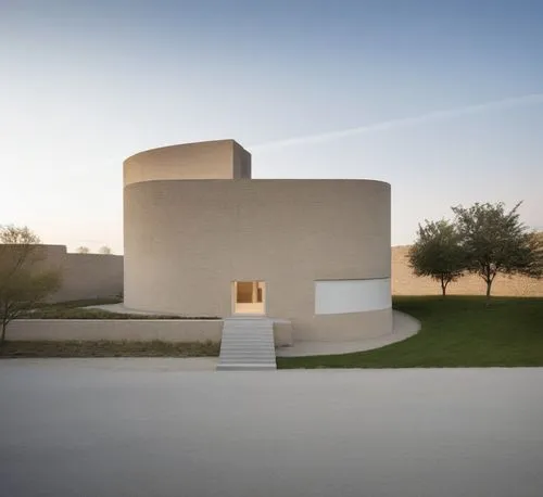 a circular building in the middle of some grass,siza,goetheanum,guggenheim museum,mfah,turrell,kimbell,melnikov,utzon,hejduk,qasr al watan,qasr azraq,dunes house,archidaily,moneo,mahdavi,corbu,columba