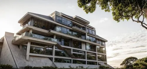 A modern tropical villa next to a hill road sorrouned by tropical trees and plants on a sunday windy afternoon. There are street lights in front of it.,gladesville,landscape design sydney,landscape de